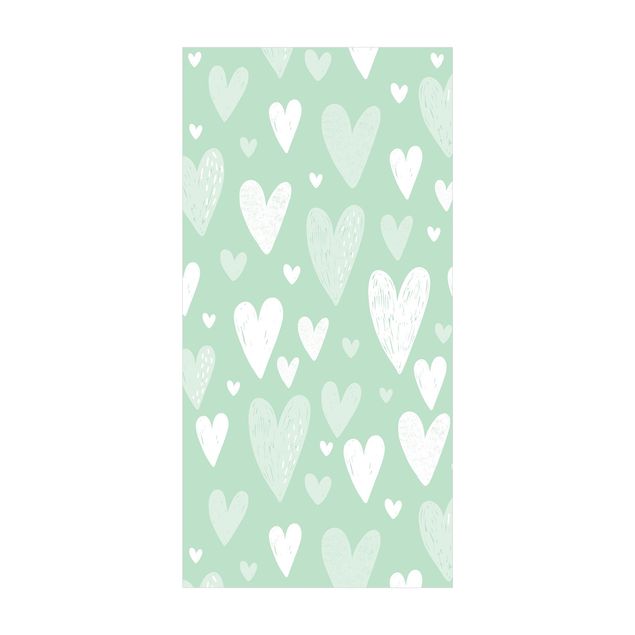 tapis contemporain Petits et grands cœurs blancs dessinés sur fond vert