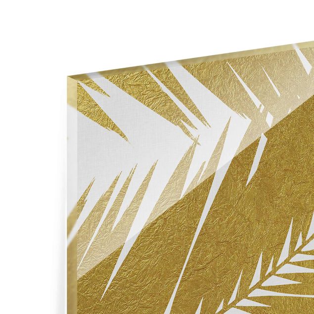 Tableaux en verre magnétique Vue à travers des feuilles de palmier dorées